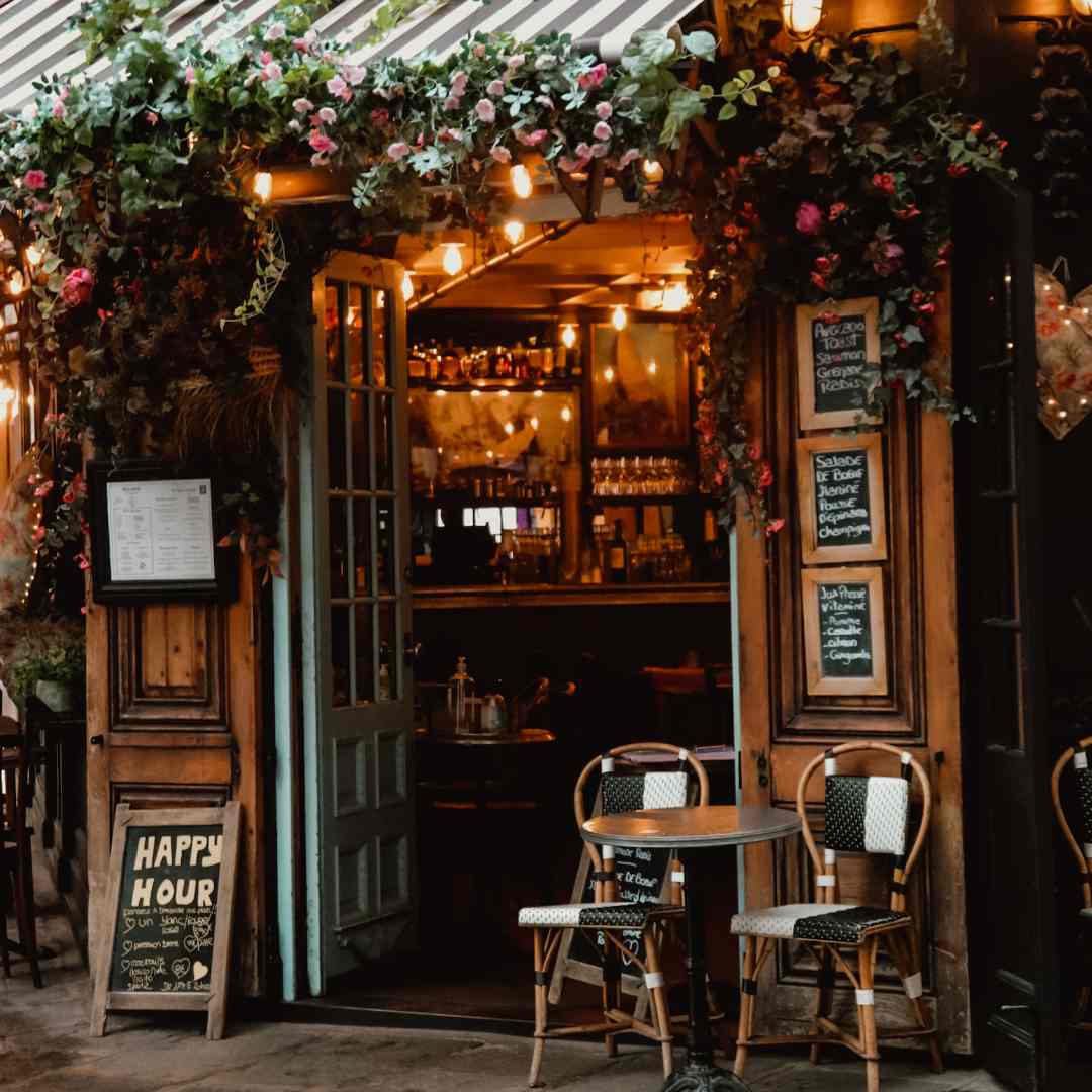 Eingang zu einem gemütlichen, warmen Café. Schöne Blumen dekorieren ihn.